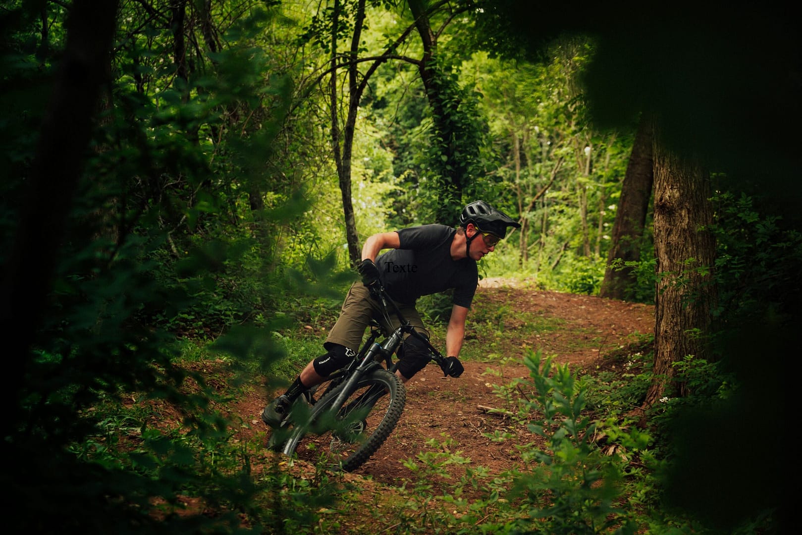 Vététiste en action dans un virage en forêt, idéal pour les passionnés d'enduro séjournant à la Grande Cabane du Blanc Ruxel.