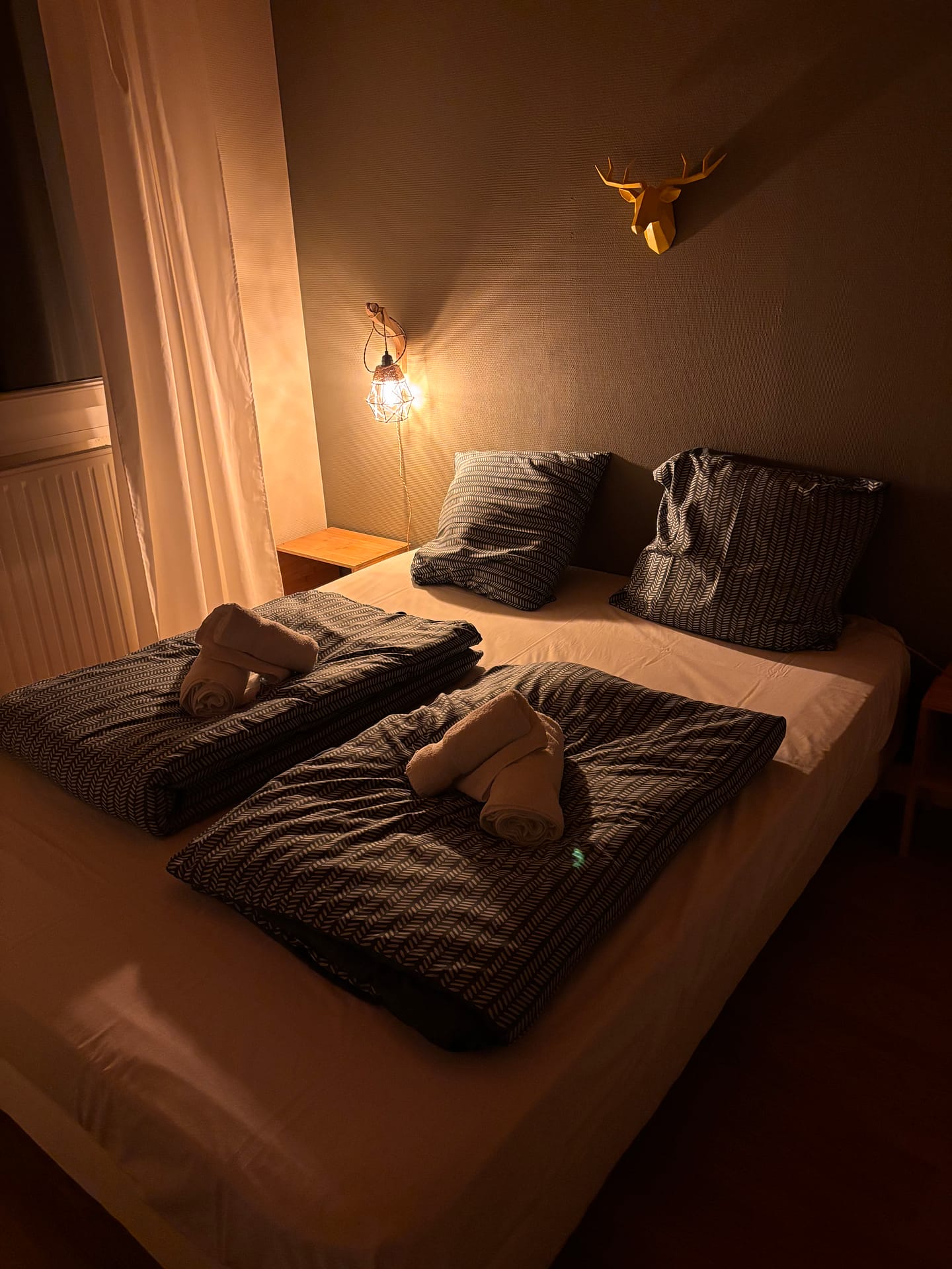 Chambre cosy avec éclairage chaleureux dans le gîte La Grande Cabane à Xonrupt-Longemer.